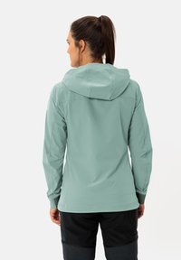 Light teal waterproof jacket with a hood, featuring a smooth texture and fitted design. Elastic cuffs and a clean, minimalistic look.