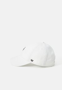 Gorra de béisbol blanca con visera curva, pequeño logotipo negro bordado "'47" en un lado y correa ajustable en la parte posterior.