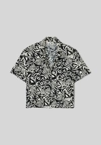 Chemise noire et blanche à manches courtes avec boutons, avec un motif léopard audacieux et feuilles abstraites, col classique et ourlet raccourci.