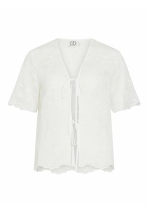 Blouse blanche à manches courtes avec broderie florale, bords festonnés, col en V et fermetures à nouer à l'avant.