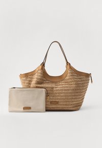 Sac fourre-tout en paille tressée couleur taupe avec des accents en cuir et des poignées doubles, accompagné d'une petite pochette zippée beige.