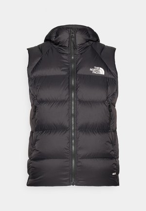 Gilet rembourré noir avec capuche, fermeture éclair à l'avant et poches latérales. Présente un logo sur la poitrine et un matériau texturé avec une finition lisse.
