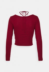 Bordowy top z długim rękawem o prążkowanej fakturze, skrócony fason, szeroki dekolt i regulowany detal z wiązaniem z tyłu.