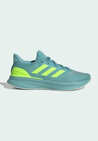 Zapatilla deportiva de color azul claro con tres rayas reflectantes en amarillo-verde, parte superior texturizada, cuello acolchado y una media suela texturizada para mayor amortiguación.