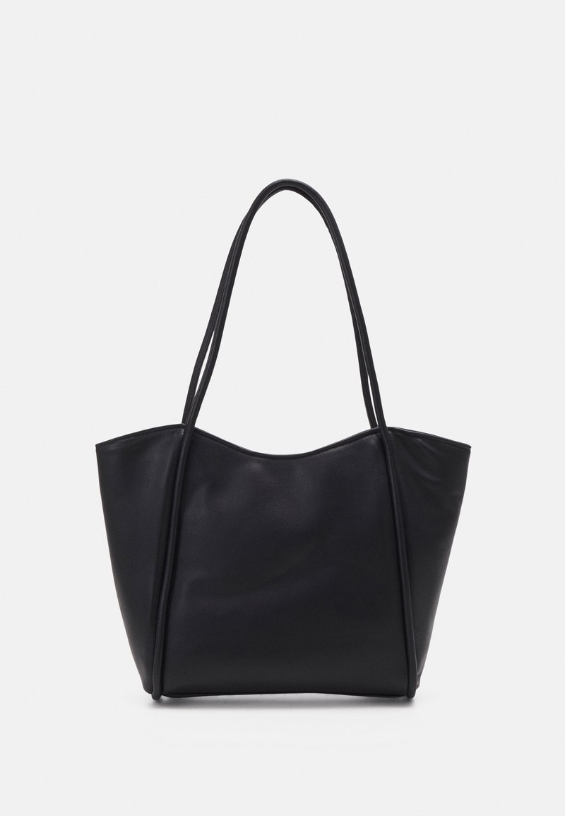 Sac cabas en cuir noir avec deux longues poignées fines et un bord supérieur légèrement incurvé sur un fond blanc uni.