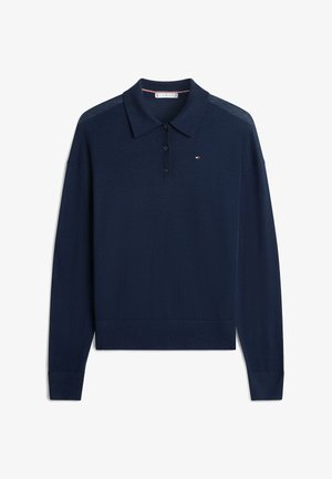 Jersey de polo azul marino de manga larga con tres botones negros y pequeño logo rojo, blanco y azul en el pecho izquierdo.