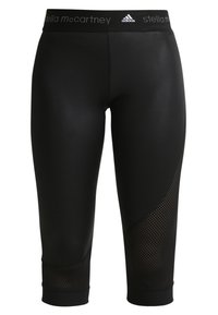 Czarne legginsy 3/4 z siateczkowymi panelami na dolnej części nóg, ozdobione elastycznym pasem z logo "Stella McCartney" oraz Adidas.