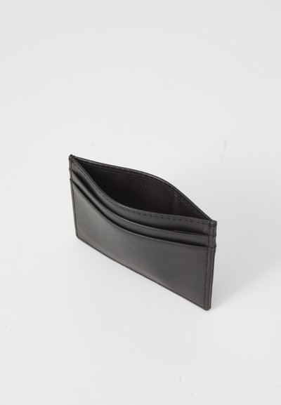 Portefeuille en cuir noir au design fin, comportant deux pochettes pour cartes et une surface texturée, présenté en angle sur un fond blanc.
