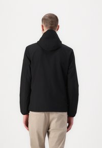 Sort hættejakke med en glat tekstur, slim fit og synlige stikninger. Let materiale velegnet til afslappet brug.