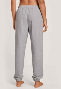 Grijze sweatpants met een elastische tailleband en boorden, gemaakt van zachte stof. Beschikt over een relaxte pasvorm en een gladde textuur.