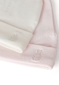 Dos gorritos para bebé: uno blanco y otro rosa. Cada gorrito tiene una tela texturizada con un patrón sutil y un logo bordado de un conejo en el puño.