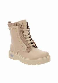 Botas ankle beige con un acabado texturizado, volantes decorativos, tachuelas doradas y suela gruesa. Presenta un cordón en la parte delantera y un detalle de logo.