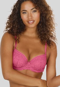 Fuchsia lace bra with molded cups, adjustable straps, scalloped edges, and floral pattern, featuring a center bow detail.