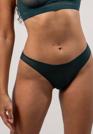 Mörkgröna bikiniunderkläder med en slät textur, med en låg midja och delikat vågkant. Enkel, minimalistisk design.