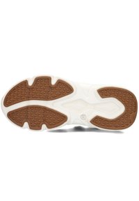 White athletic shoe outsole with a gum rubber traction pattern, featuring a textured surface and defined grip zones for stability.