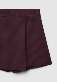 Burgunderfarbene Shorts mit vertikalen Nadelstreifen, die ein gefälteltes Design und einen verdeckten Reißverschluss aufweisen. Der Stoff wirkt glatt und maßgeschneidert.