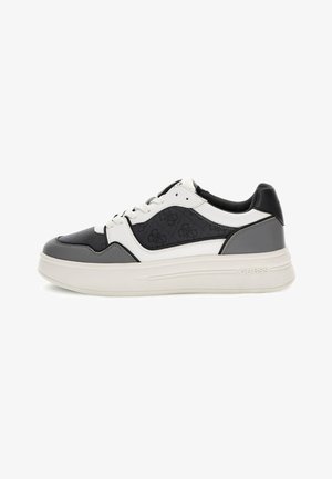 Zapatilla blanca, negra y gris con suela alta, fabricada en materiales de cuero y textil, con un logotipo de marca prominente y diseño de cordones.
