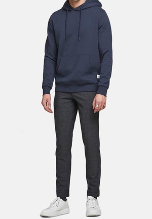 Marineblauer Kapuzenpullover mit Kordelzügen, Fronttasche, kombiniert mit karierten Slim-Fit-Hosen und weißen Sneakern. Weicher Stoff mit glatter Textur.