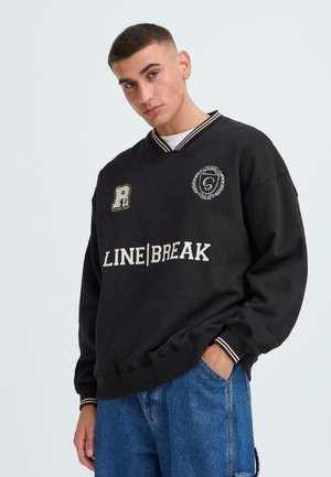 Black sweatshirt with a V-neck, ribbed cuffs, and white text “LINE|BREAK.” Features embroidered logos and a soft, textured fabric.