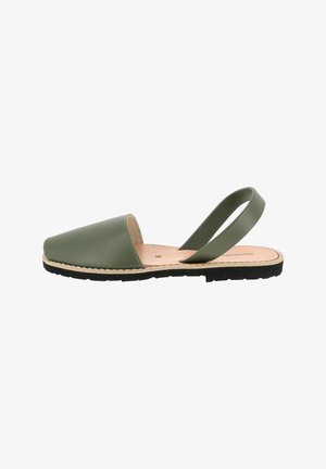 Sandale en cuir vert avec un bout fermé et un dos ouvert, dotée d'une fine sangle à la cheville et d'une semelle en caoutchouc noir texturé.