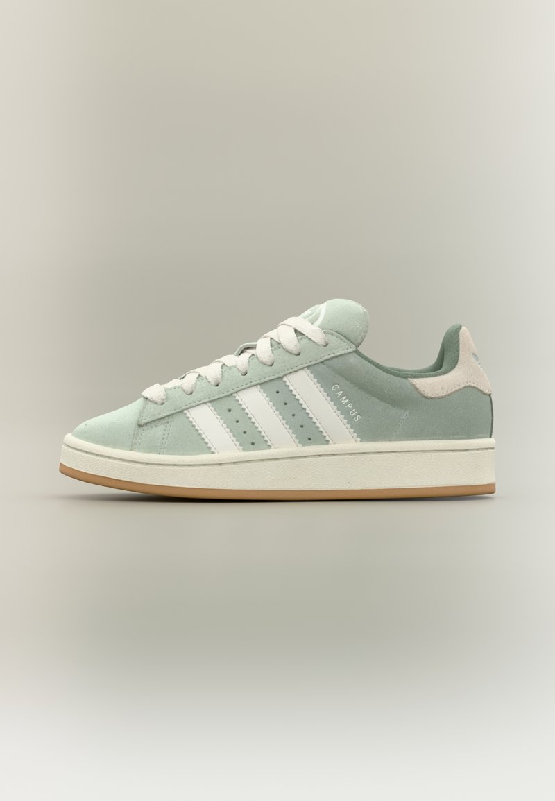 Light mint green suede sneaker with white stripes, rounded toe, rubber sole, and textured accents on the heel. Design features a classic style.