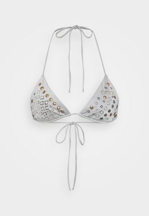 Bílý trojúhelníkový bikinový top s výřezy, kovovými akcenty v zlaté a stříbrné barvě a nastavitelnými šňůrkami pro dokonalé padnutí.