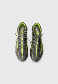 Scarpe da ginnastica nere e verde neon con una superficie testurizzata, design elegante, punta rotonda e lacci piatti. Presentano un motivo a strisce dinamiche.