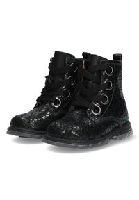 Botas negras hasta el tobillo hechas de un material texturizado con un acabado brillante. Cuentan con ojetes metálicos redondos y cordones negros, con una suela de goma.