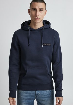 Felpa blu navy realizzata in tessuto morbido, con tasca frontale e un logo ricamato sul petto. Polsini e orlo elasticizzati.