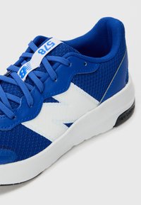 Chaussure de sport bleue en mesh et en matériaux synthétiques, avec des accents blancs et une surface texturée, conçue pour le confort et le soutien.