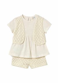 Completo due pezzi color crema composto da una maglietta a maniche corte con un gilet in pizzo e pantaloni corti in pizzo abbinati, con un design peplum.