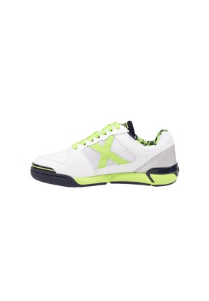 Zapatilla deportiva blanca con cordones verde neón, detalles en la suela, paneles de malla y detalles en negro, vista desde un lado.