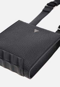 Czarna torebka ze skóry o fakturze z prostokątnym kształtem, z gładkim panelem akcentowym, regulowanym paskiem i małym trójkątnym logo.