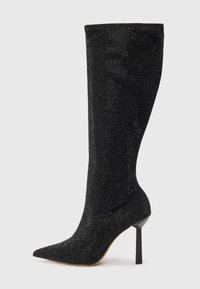 Botte noire à talons aiguilles, hauteur genou, avec un bout pointu, fabriquée dans un matériau texturé présentant un léger scintillement grâce à des sequins incrustés.