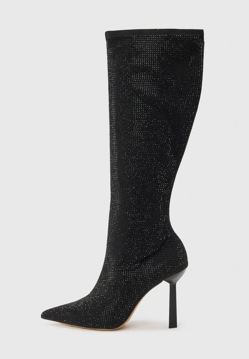 Botte noire à talons aiguilles, hauteur genou, avec un bout pointu, fabriquée dans un matériau texturé présentant un léger scintillement grâce à des sequins incrustés.