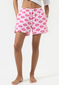 Roze katoenen shorts met een herhaald patroon van rode lippen, elastische tailleband met trekkoord en zijzakken. Zachte stof met een ontspannen pasvorm.