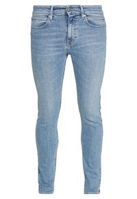 Vaqueros de mezclilla azul claro con corte ajustado, que presentan una cintura de altura media, cinco bolsillos y un ligero desgastado en toda la tela.