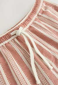 Red and white striped fabric, featuring a textured weave with lace detail, elastic waistband, and a white drawstring.