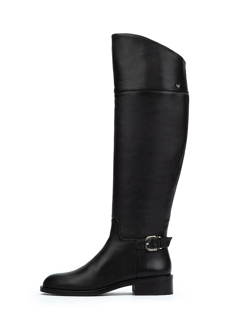 Bota de cuero negro hasta la rodilla con textura suave, punta redondeada, tacón bajo y detalle de hebilla lateral. Diseño único del eje alto.