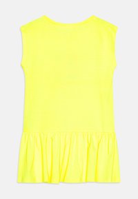 Top senza maniche realizzato in tessuto giallo brillante, con orlo a volant arricciato. Texture liscia con scollatura arrotondata e vestibilità casual.