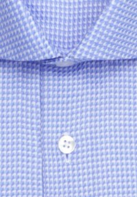 Camicia azzurro chiaro con bottoni, caratterizzata da un motivo geometrico e testurizzato. Ha un colletto classico e dettagli con bottoni bianchi.