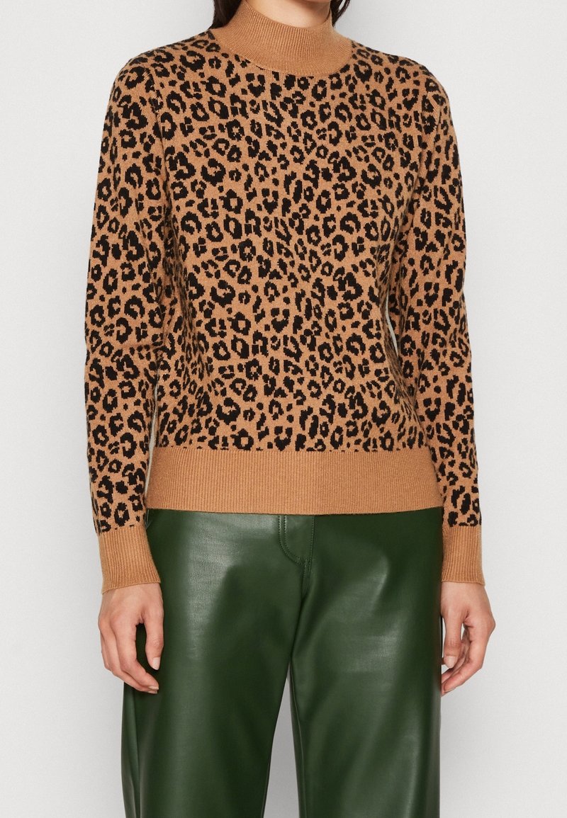 Hnědý svetr s leopardím vzorem, vysokým límcem, žebrovanými manžetami a lemem. Kombinovaný se zelenými koženými kalhotami. Měkká pletená textura.