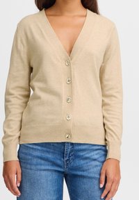 Beige pletený svetřík s hlubokým V-výstřihem, šesti zlatými knoflíky vpředu a žebrovanými manžetami. Hladká textura a uvolněný střih.