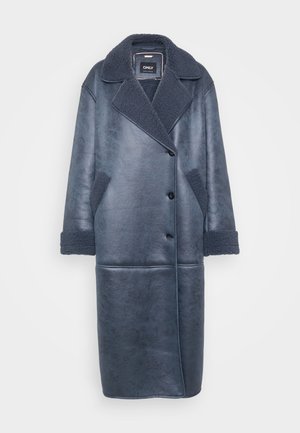 Lang donkerblauwe leren jas met een gestructureerde afwerking, voorzien van een luxe kraag, een sluiting met knopen aan de voorkant en zijzakken met schapenvacht accenten.