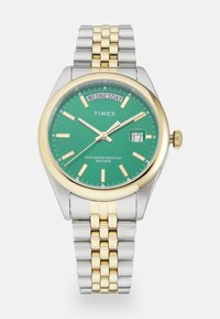 Silver and gold-tone stainless steel watch with a green dial, featuring date display, marked days, and a two-tone band.