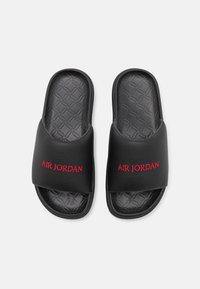 Black slide sandals with a textured black footbed. Features a wide strap and the "AIR JORDAN" logo in red across the upper.