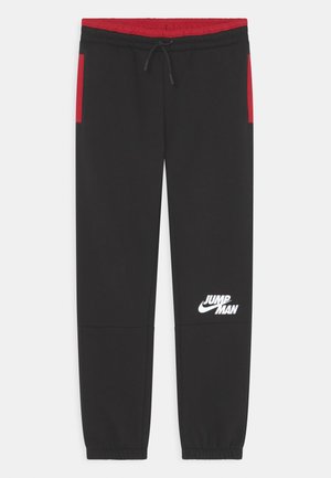 Sorte træningsbukser med rød linning og sidelommer, elastiske manchetter, snøre i taljen og hvid "Jumpman"-logo på højre lår.