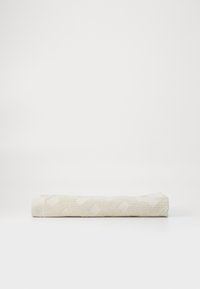 Asciugamano bianco arrotolato con superficie testo; presenta motivi circolari in una tonalità leggermente più chiara per un dettaglio aggiuntivo. Realizzato in tessuto assorbente.
