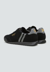 Sneakers nere in suede con strisce grigie, caratterizzati da una forma elegante, suola in gomma nera e dettagli in oro sui lati e sul tallone.