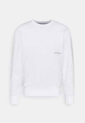 Witte trui met lange mouwen en ronde hals met het Calvin Klein Jeans-logo op de linkerborst, geribbelde manchetten, zoom en halslijn.
